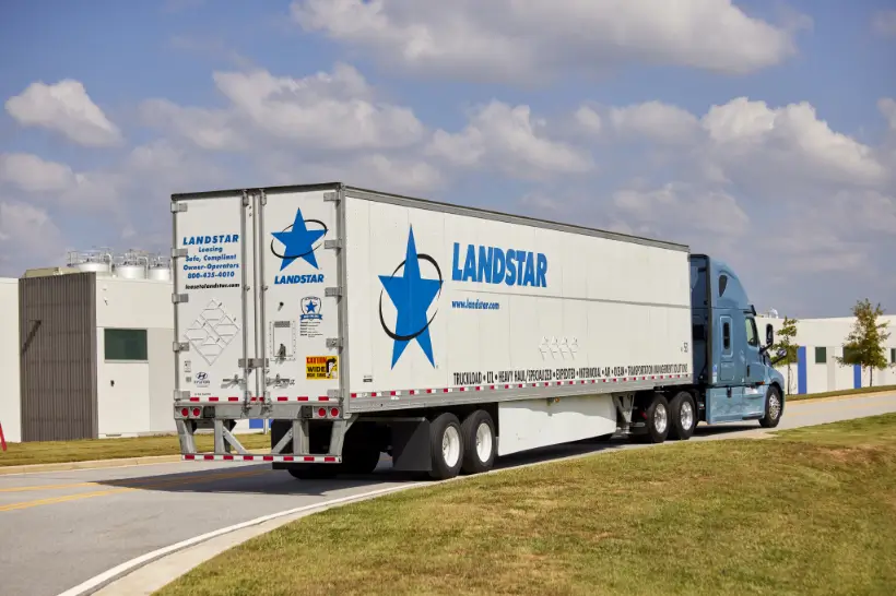 A large semi truck driving along a highway, highlighting its powerful build and cargo capacity.